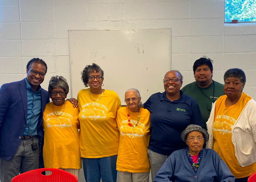 A group of people stand next to each other and smile