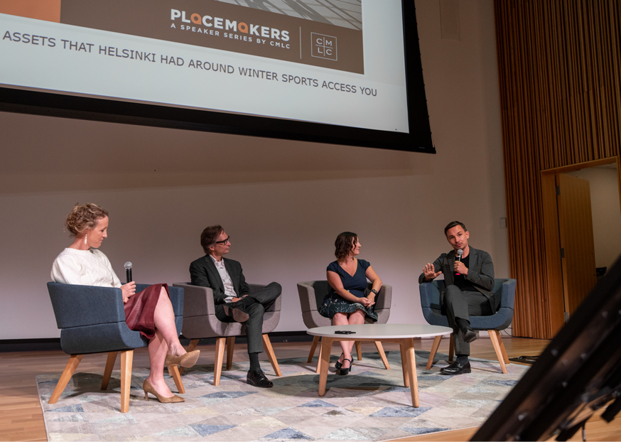 A group of people seated on stage holding microphones